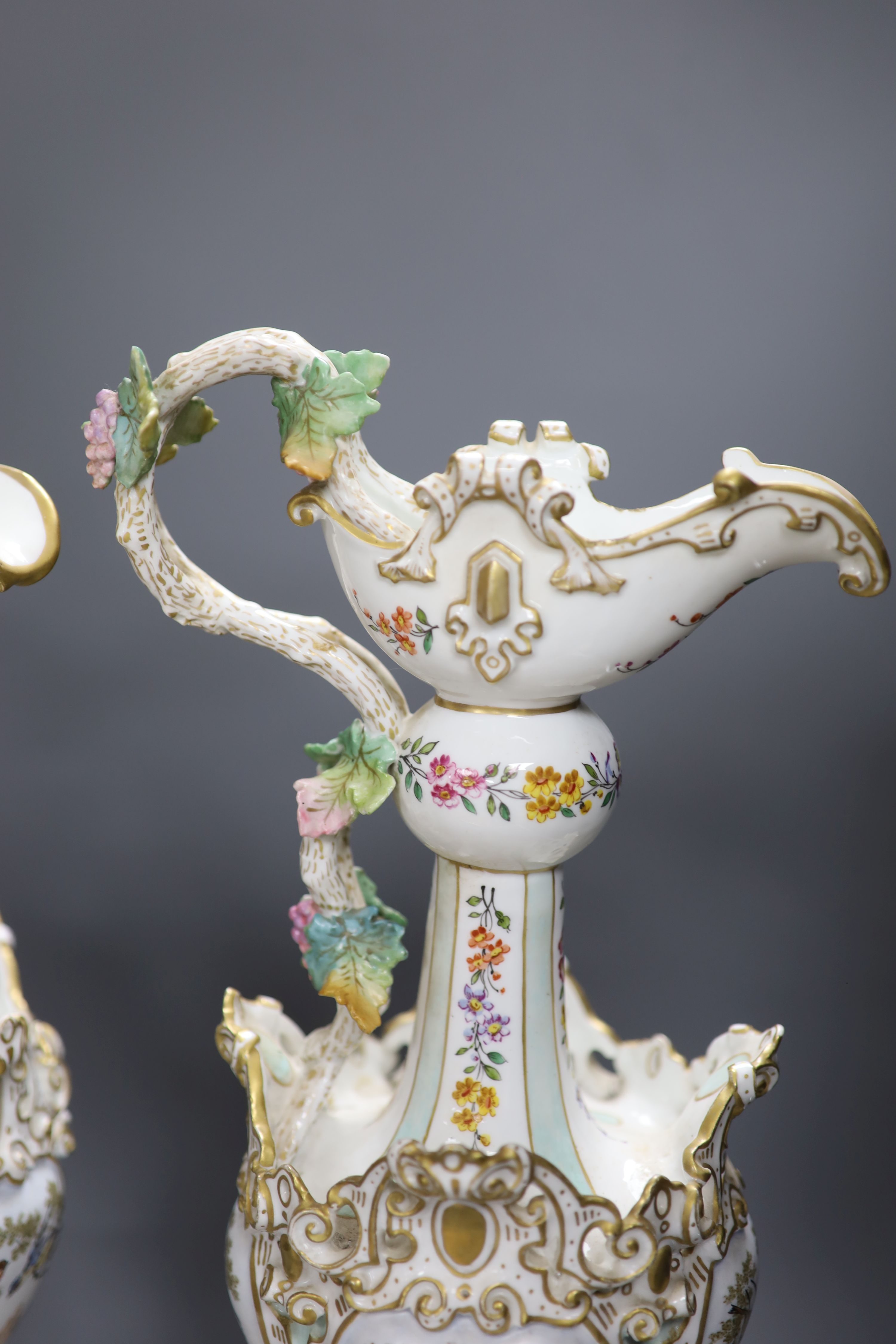 A pair of 19th century German floral and bird painted ewers, height 50cm